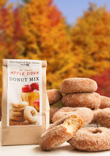 Load image into Gallery viewer, Apple cider donut mix packaging with donuts against an autumn background