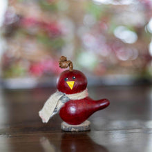 Load image into Gallery viewer, Red bird figurine with a yellow beak on a wooden surface