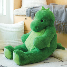 Load image into Gallery viewer, Green plush dragon toy on a bed with pillows and a blanket in the background