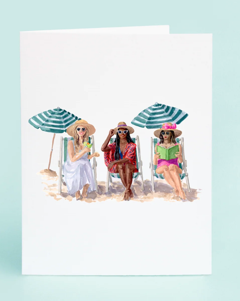 Three women sitting on beach chairs under umbrellas with a light blue background

Details