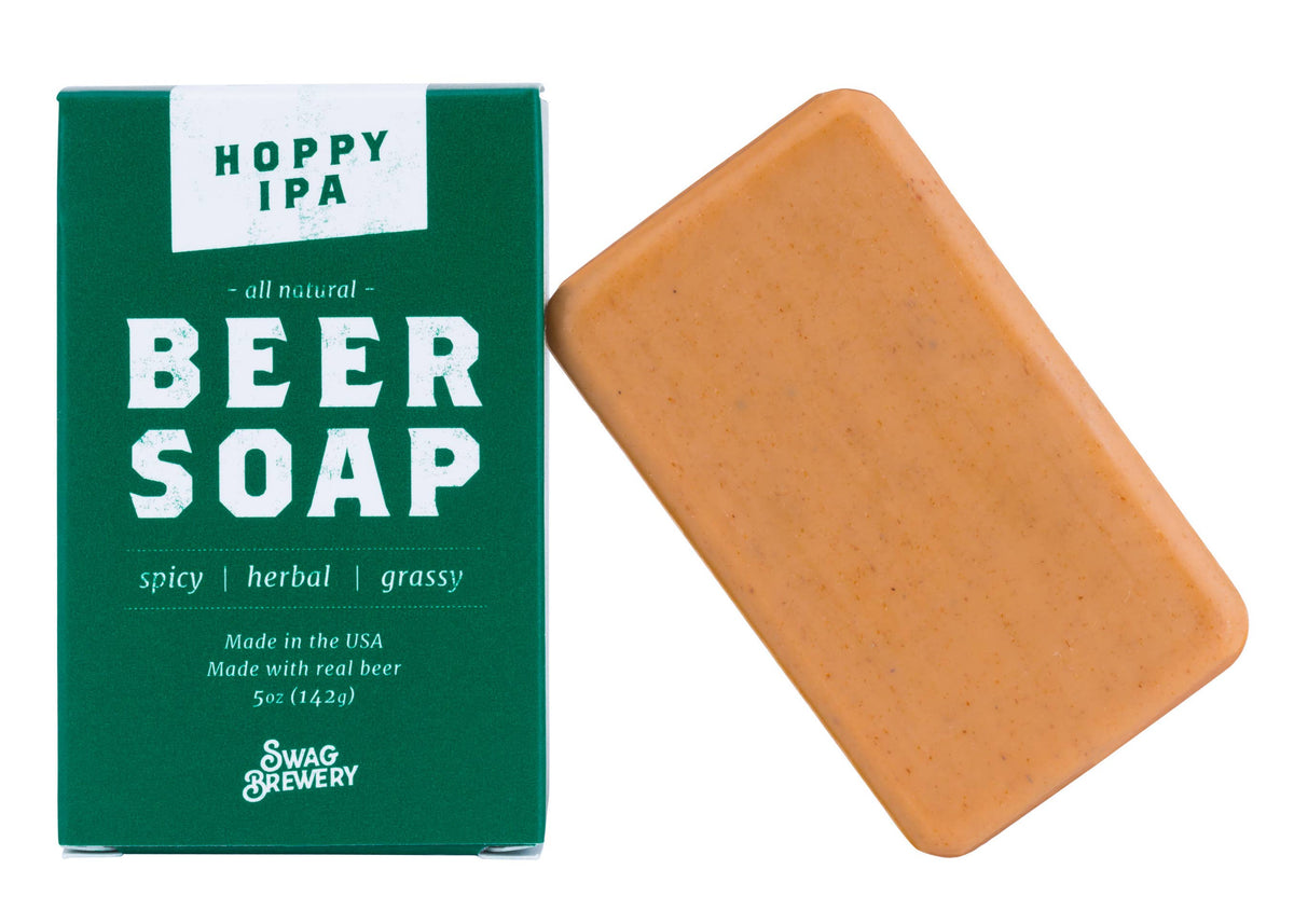 Hoppy IPA Beer Soap by Swag Brewery, featuring a green cardboard box with white text next to a rectangular bar of orange-brown soap on a white background.