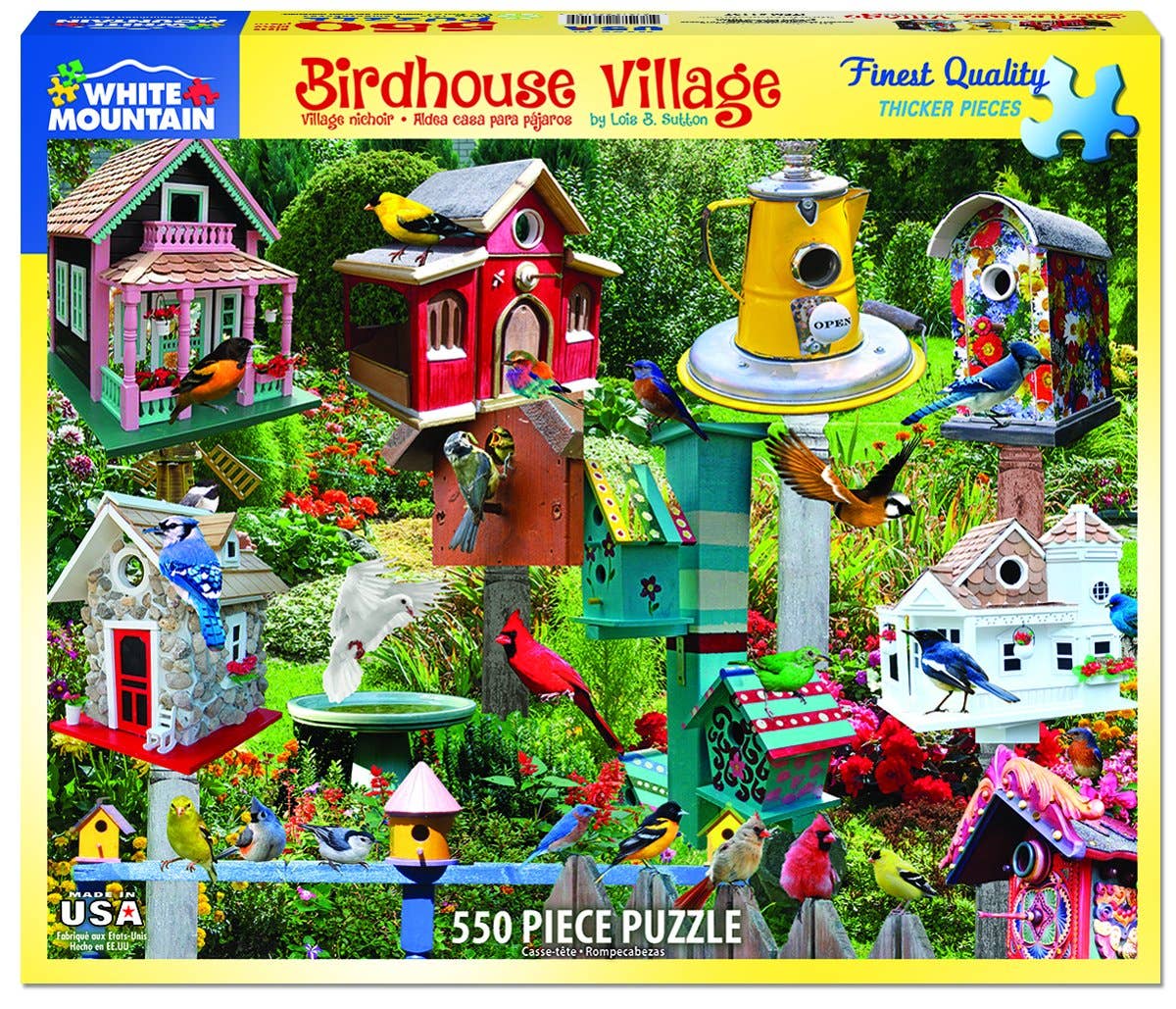 Front of a White Mountain 'Birdhouse Village' 550-piece jigsaw puzzle box, featuring a colorful collage of various birdhouses, birds, and garden details on a bright yellow border.