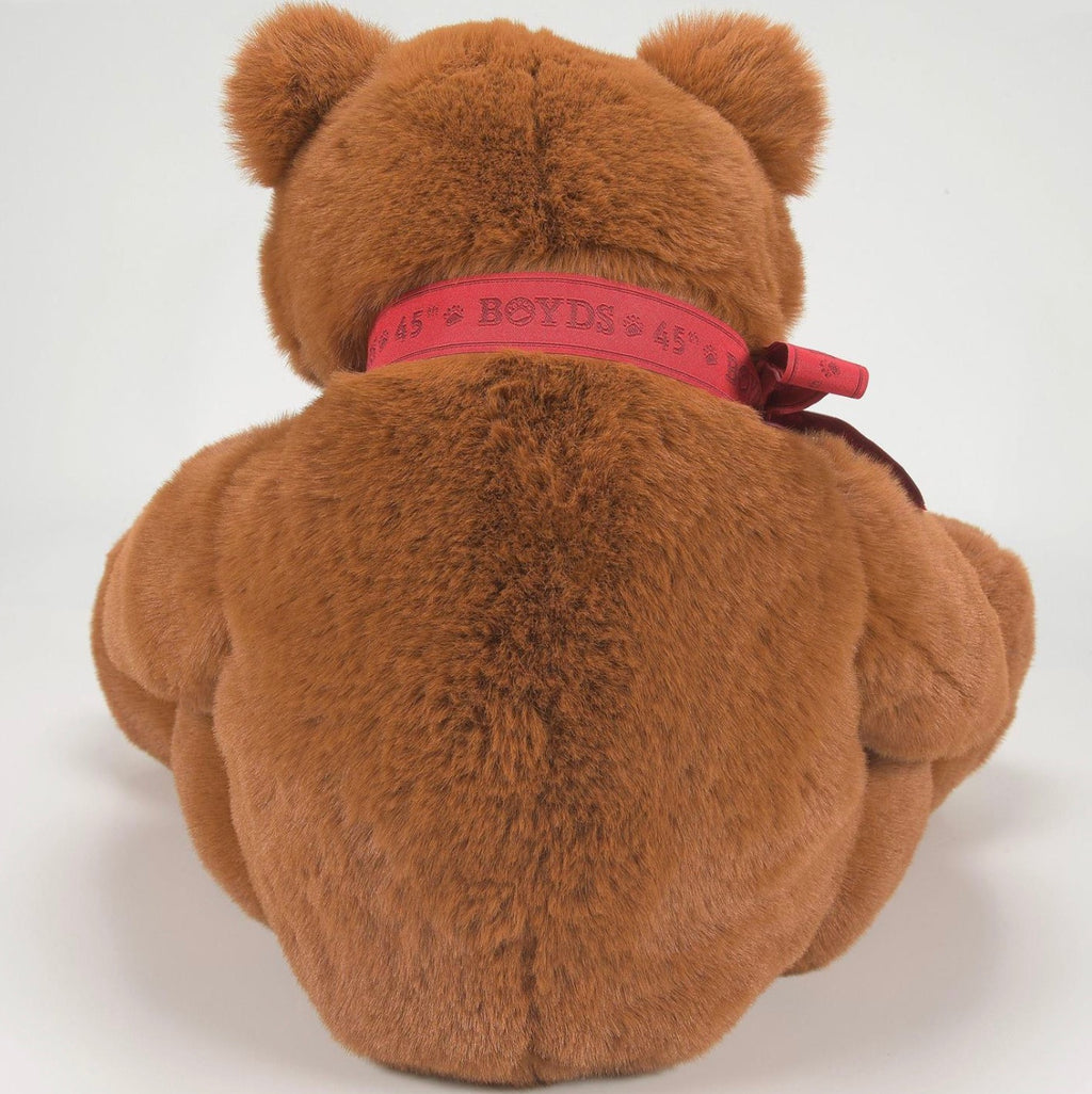 Brown teddy bear with a pink ribbon on a white background