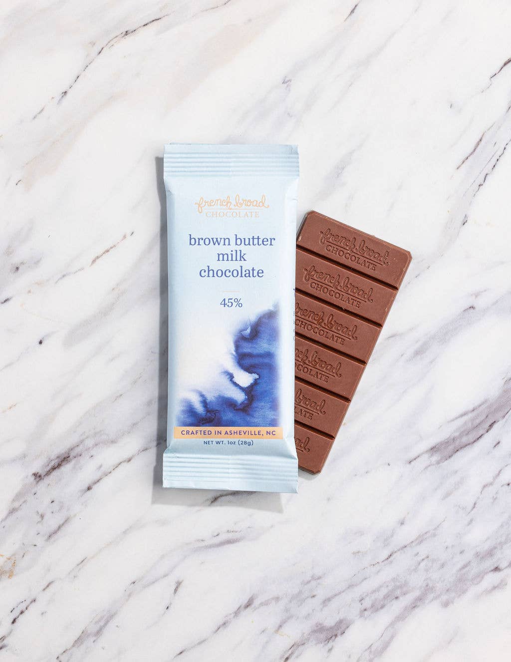 Brown butter milk chocolate bar with packaging on a marble surface