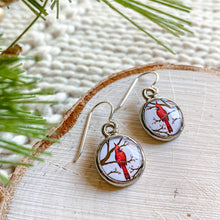 Load image into Gallery viewer, Cardinal earrings on a wooden surface with greenery
