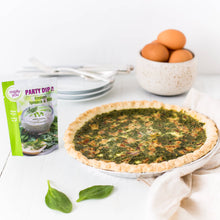 Load image into Gallery viewer, Spinach quiche on a white surface with a package of Party Dip and a bowl of eggs in the background.
