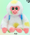 A plush monkey toy with white fur and pastel rainbow tie-dye patches, pink face and feet, green eyes, and a smiling expression on a pale green background.
