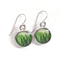 Load image into Gallery viewer, Silver earrings with green forest design on a white background
