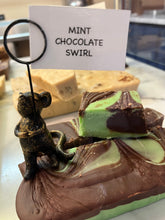 Load image into Gallery viewer, A close-up of a mint chocolate swirl bar decorated with a small black mouse figurine holding a sign that reads 'MINT CHOCOLATE SWIRL'.
