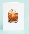 Glass of brown liquid with ice and a lemon twist on a light blue background