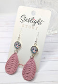 Pink feather-shaped earrings on a 'Starlight Story' branded card.