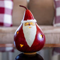 Decorative gourd shaped like Santa Claus on a table with a blurred background