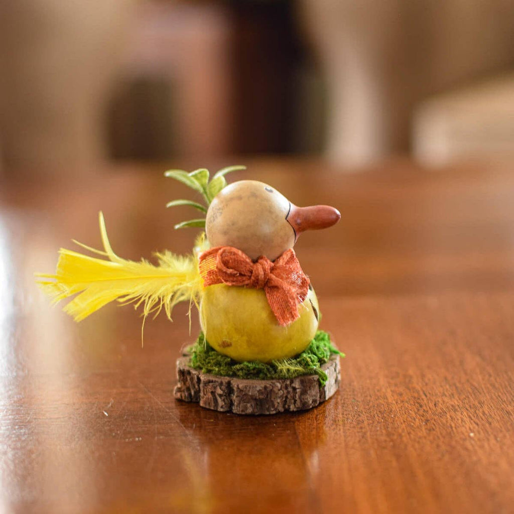 Small decorative figurine of a duck with a bow tie on a wooden surface