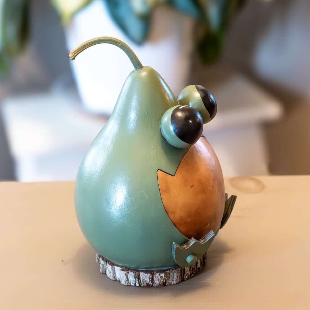 Decorative gourd shaped like a bird on a wooden surface with a blurred background