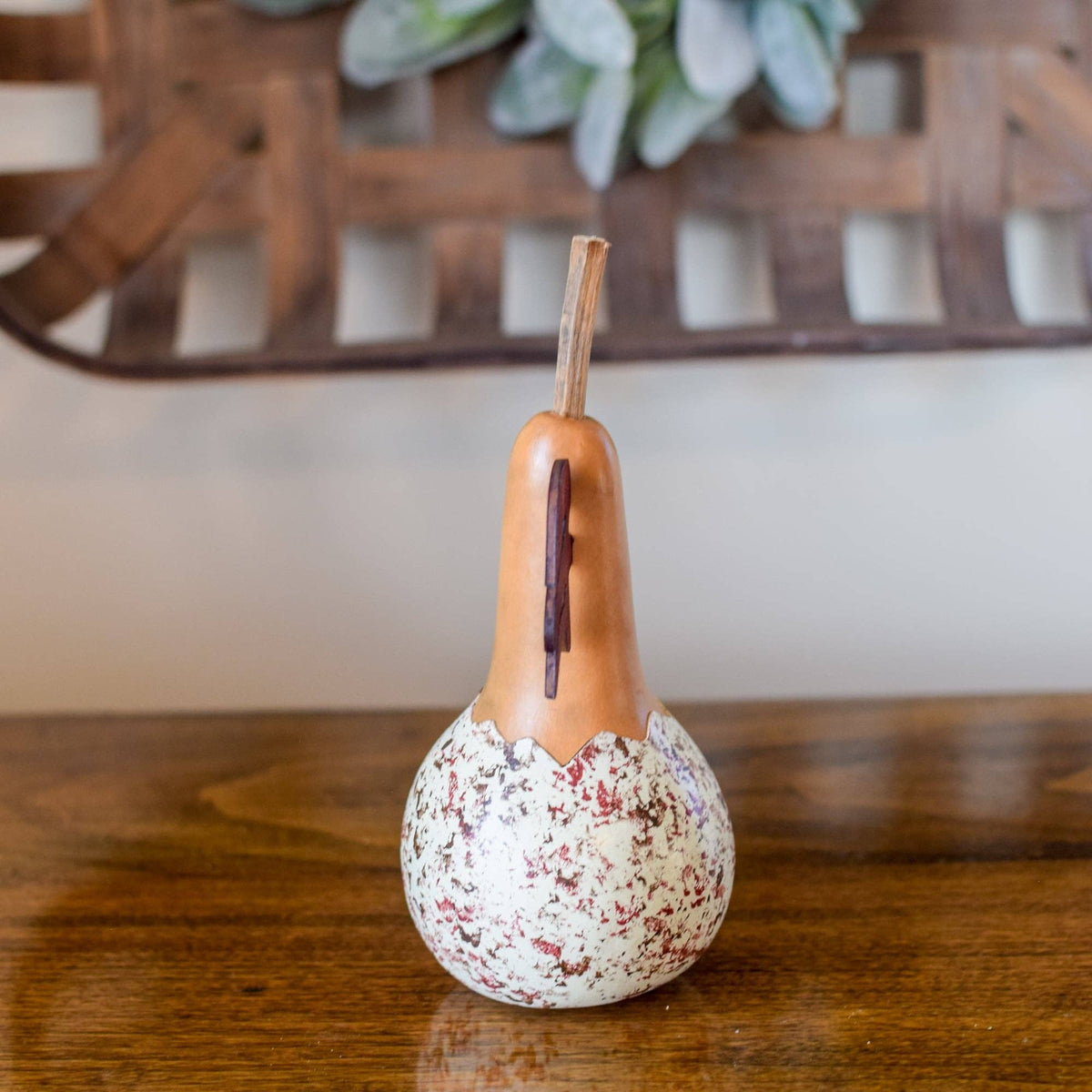 Decorative gourd with speckled pattern on a wooden surface