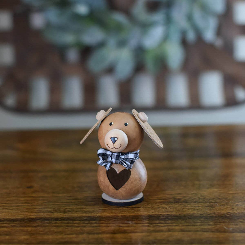 Small wooden dog figurine with a heart on a wooden surface