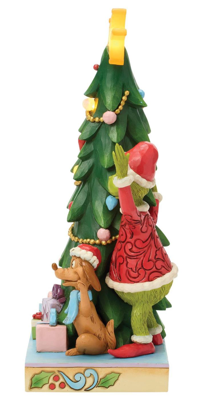 Decorative figurine of a character climbing a Christmas tree with a dog below, on a white background.