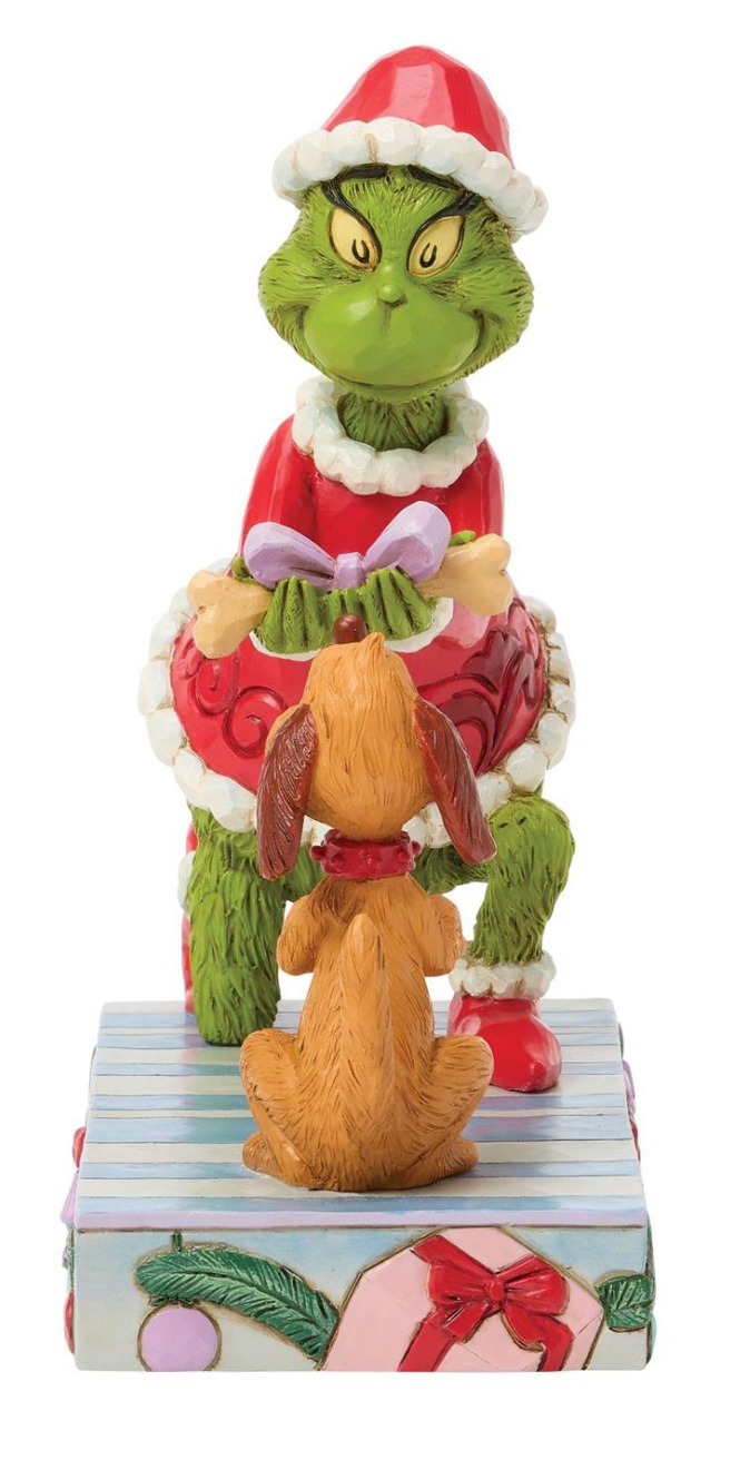 Figurine of a green character and a dog in festive attire on a white background