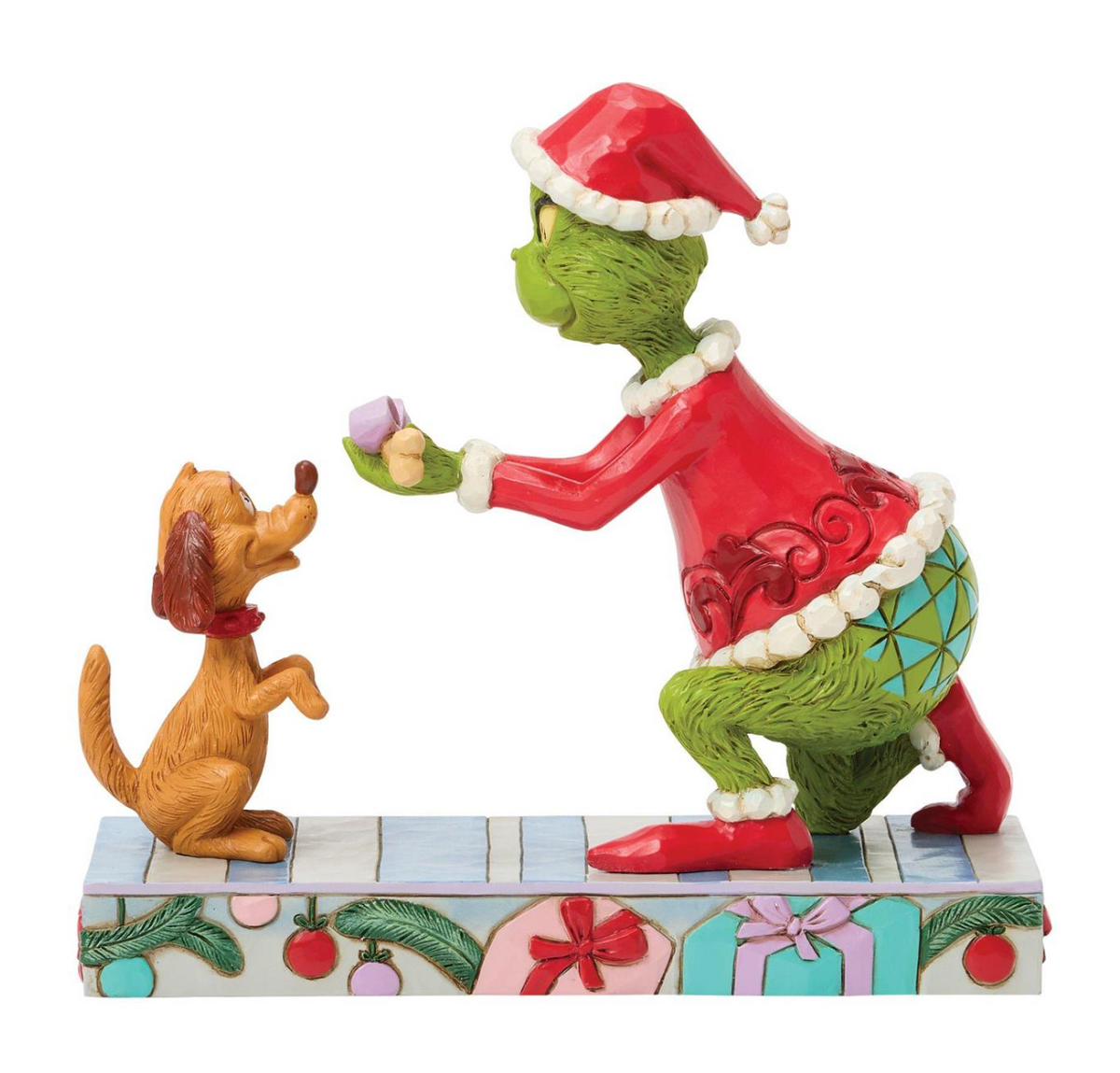 Figurine of a green character in a red outfit and Santa hat interacting with a brown dog on a decorative base.