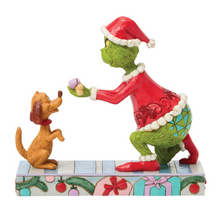 Load image into Gallery viewer, Figurine of a green character in a red outfit and Santa hat interacting with a brown dog on a decorative base.
