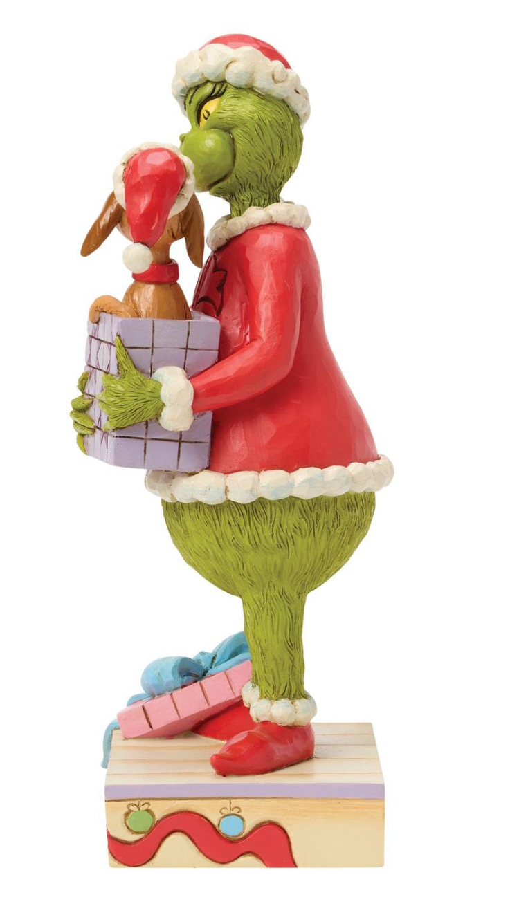 Statue of a green character in a red outfit holding a gift box on a white background