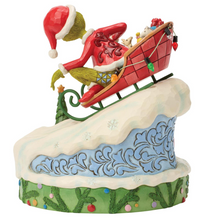 Load image into Gallery viewer, Christmas-themed figurine of a character with a red hat and green scarf sliding down a snowy slope.
