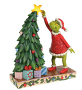 Figurine of a character decorating a Christmas tree with a star, on a white background