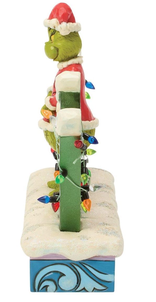 Decorative figurine of a character climbing a Christmas tree with lights on a white background