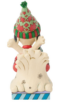 Load image into Gallery viewer, A Christmas gnome figurine peeking out from behind a snowdrift, wearing a green and red patterned hat and scarf, with a blue and white striped base.
