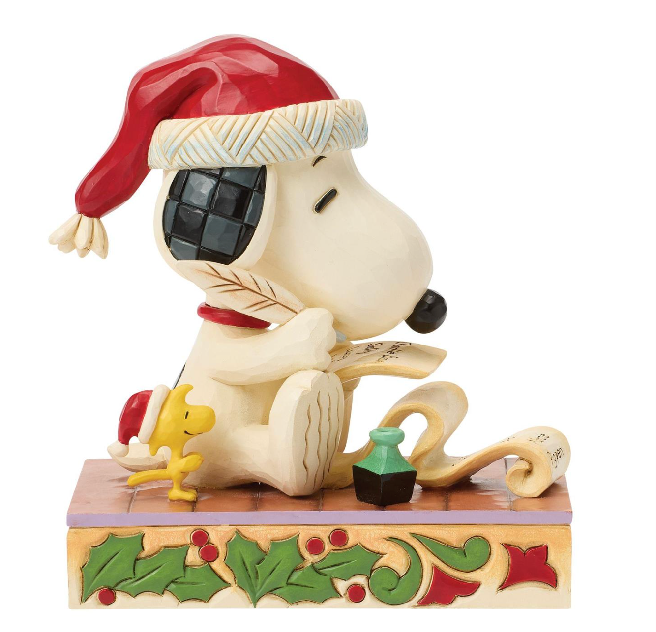 A decorative figurine of Snoopy wearing a red Santa hat and reading a scroll, with Woodstock beside him and a holly-accented base, photographed on a plain white background.