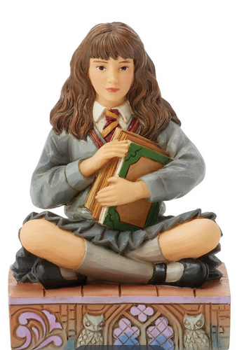 Figurine of Hermione in a school uniform holding books on a decorative base with owls. Artist Jim Shore.