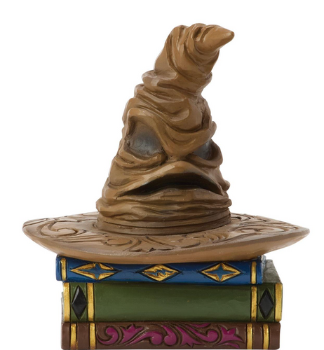 Figurine of a Sorting Hat from Harry Potter on top of books with decorative elements on a white background. Artist Jim Shore.