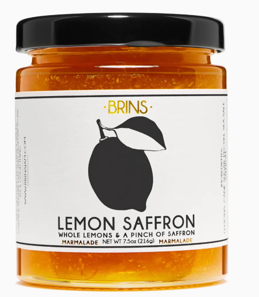 Jar of lemon saffron marmalade with a black lid on a white background