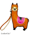 An orange alpaca-shaped leather wristlet wallet with a matching wrist strap, featuring a pink patterned saddle design on its back, set against a plain white background.