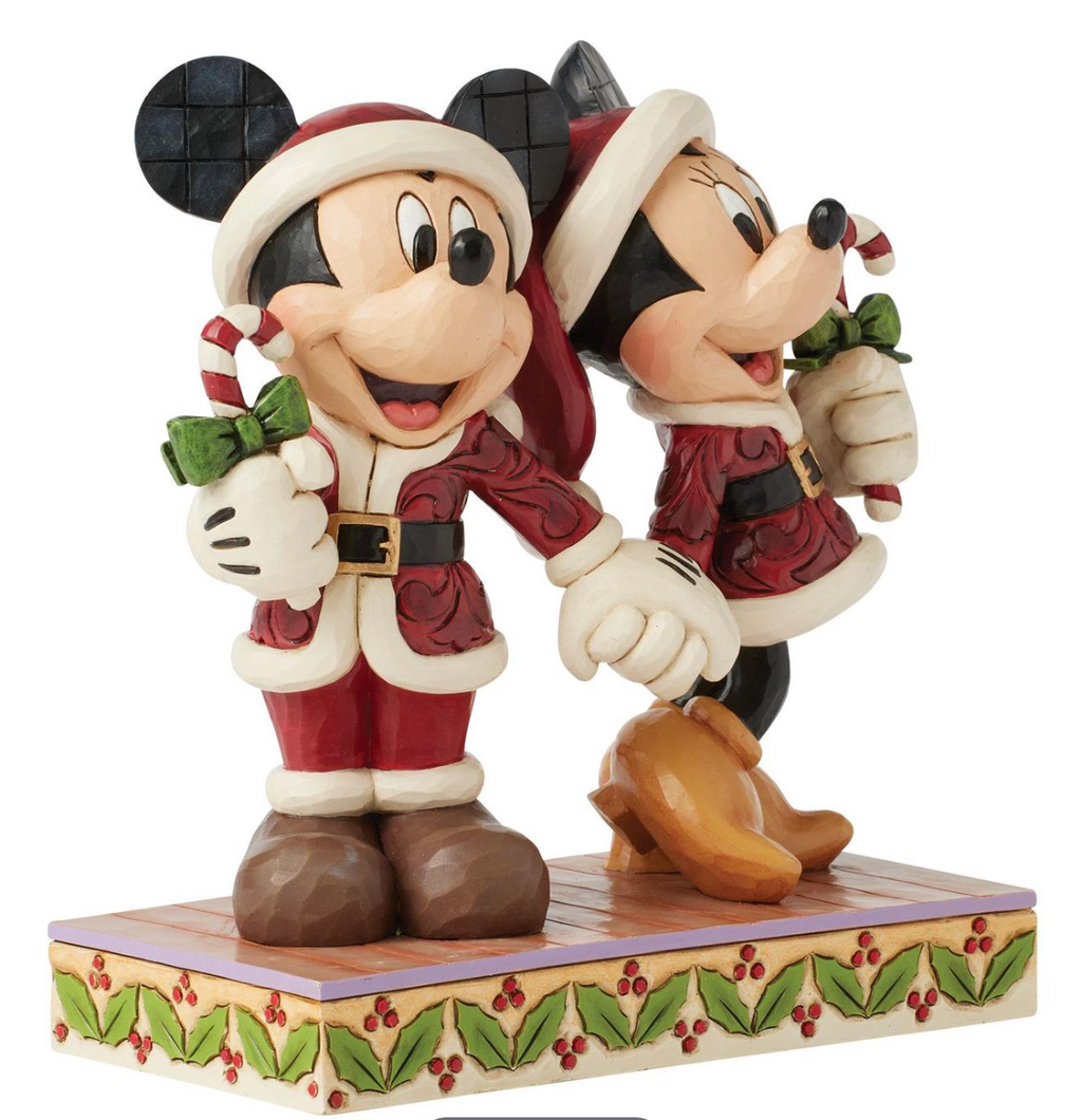 Christmas-themed figurine of two characters in festive attire on a white background