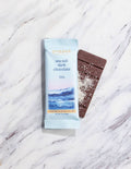 Sea salt dark chocolate bar with packaging on a marble surface
