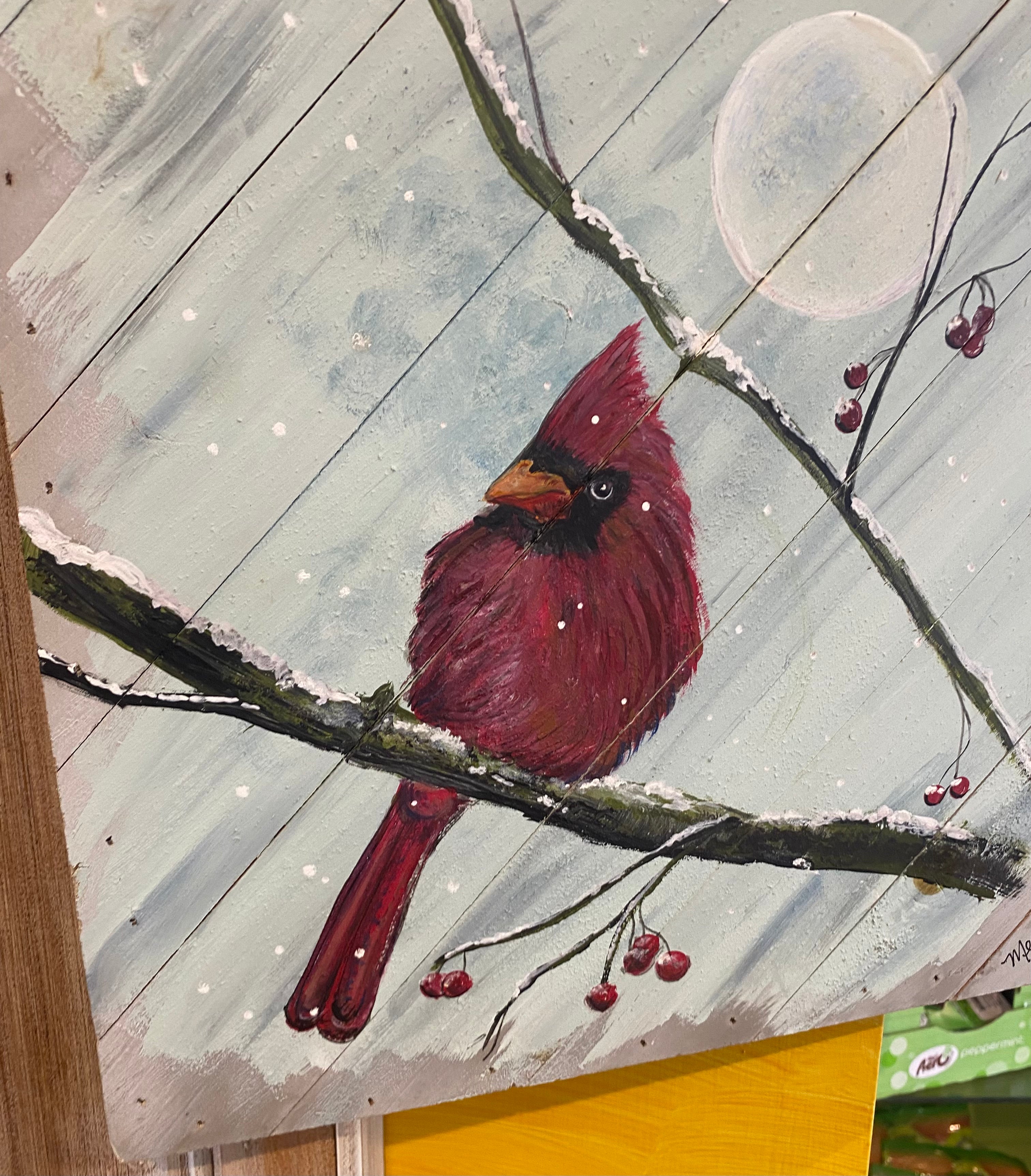 Cardinal bird on a branch with berries and snowflakes in the background