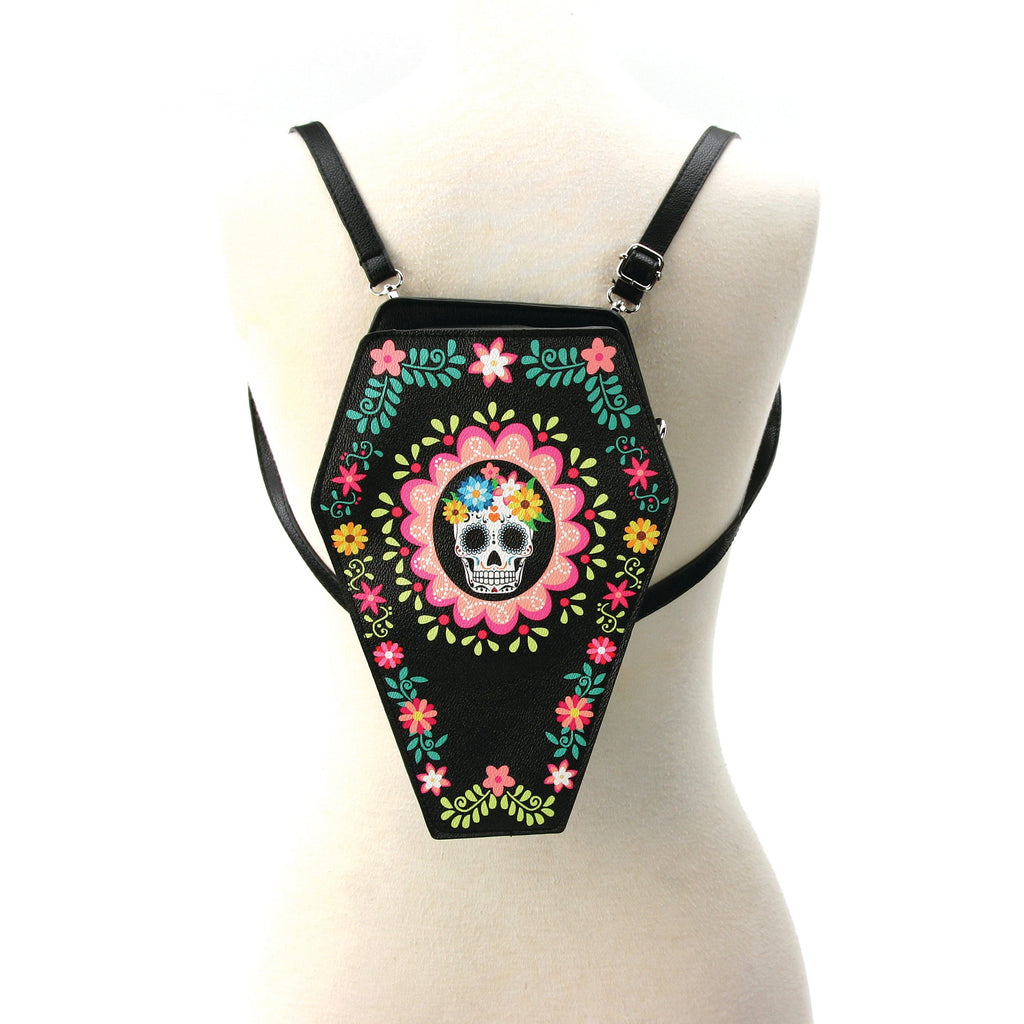 Black coffin-shaped bag with colorful floral and skull design on a mannequin.