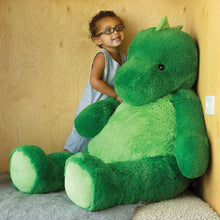 Load image into Gallery viewer, Child holding a large green teddy bear against a wooden wall.
