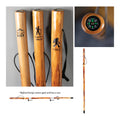 Wooden walking sticks with engraved designs and a close-up of a compass, on a gray background.