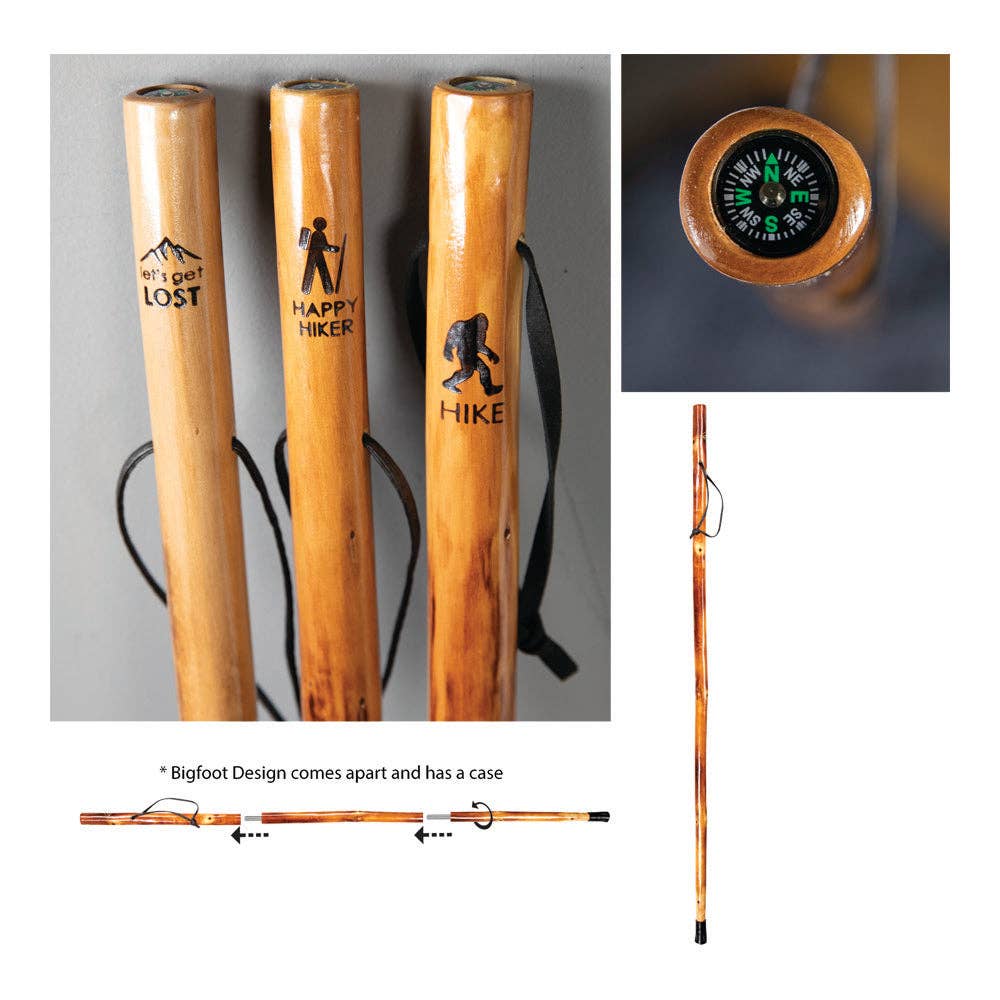 Wooden walking sticks with engraved designs and a close-up of a compass, on a gray background.