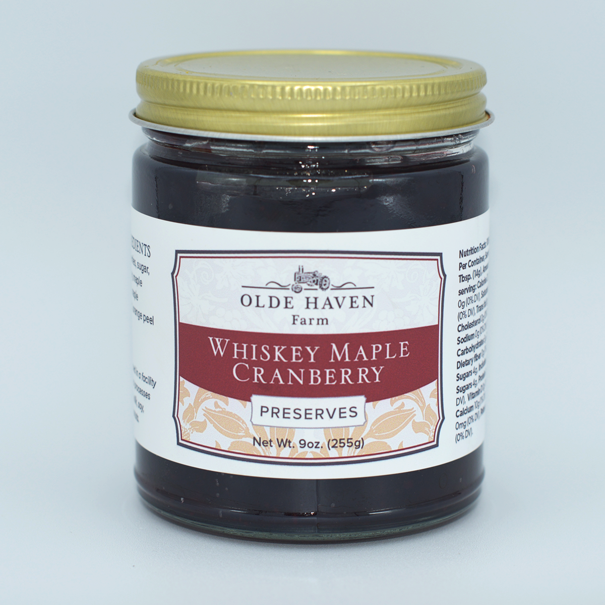 Jar of Whiskey Maple Cranberry Preserves from Olde Haven Farm on a light gray background