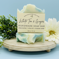 Handmade soap bar with a label on a wooden stand against a light blue background