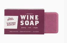 Load image into Gallery viewer, A bar of Swag Brewery Vintage Merlot wine soap shown next to its dark purple packaging box on a clean white background.
