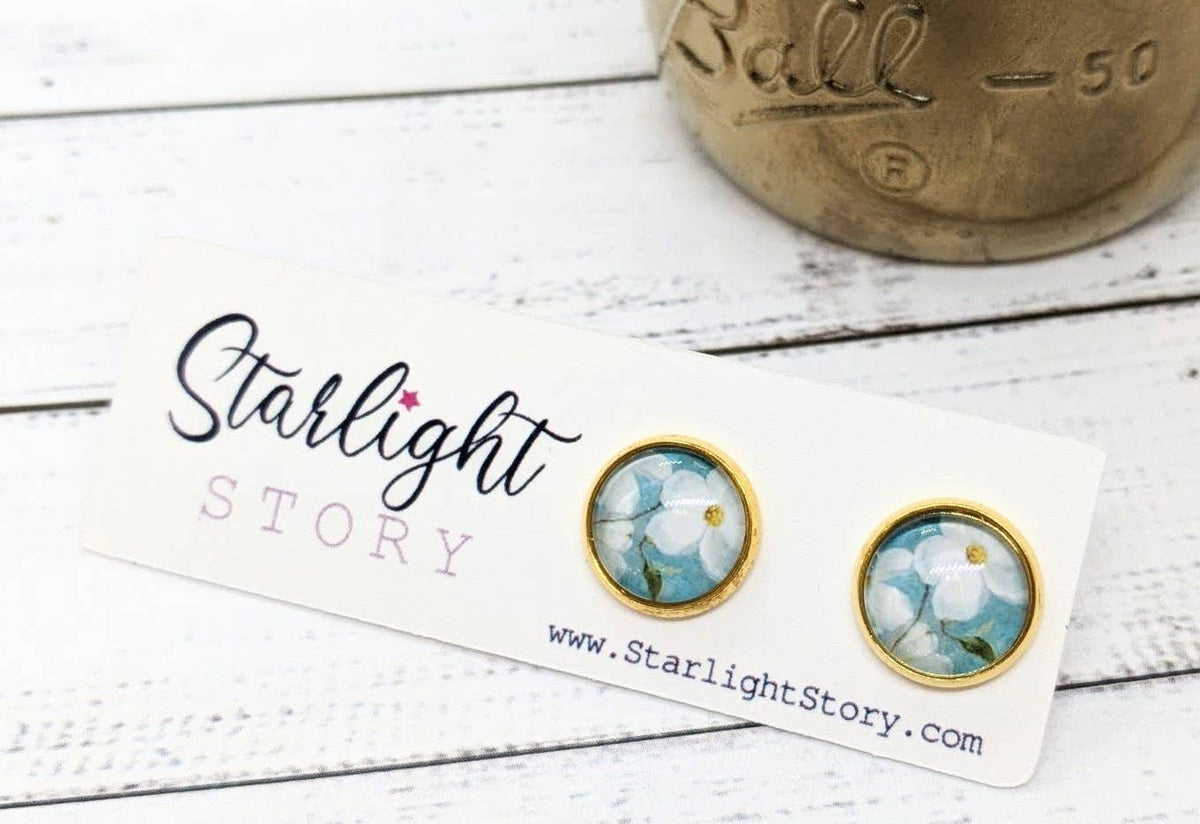 Pair of earrings with floral design on a Starlight Story branded card.