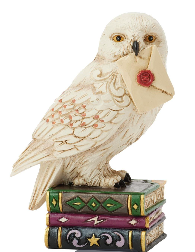 Jim Shore Figurine of Hedwig holding a letter on top of books with a white background