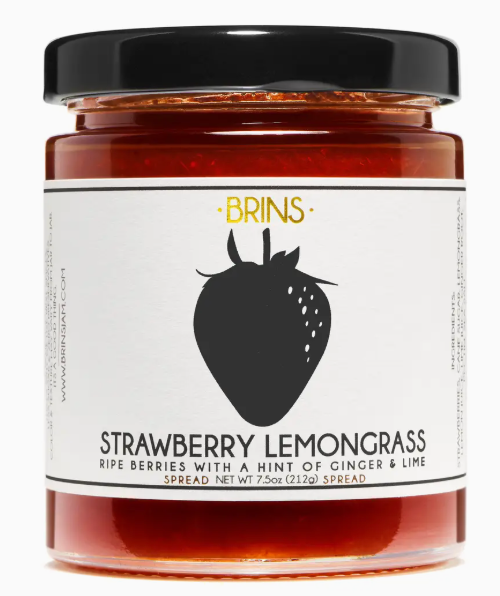 Jar of strawberry lemongrass spread with a black lid on a white background